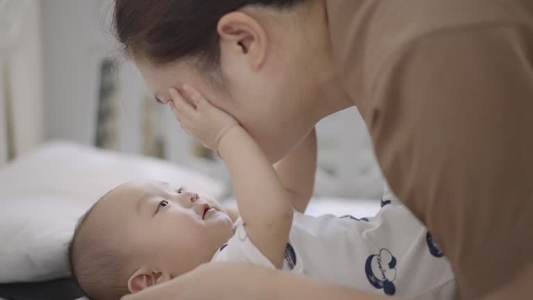 Mother playing with her baby in morning time after wake up