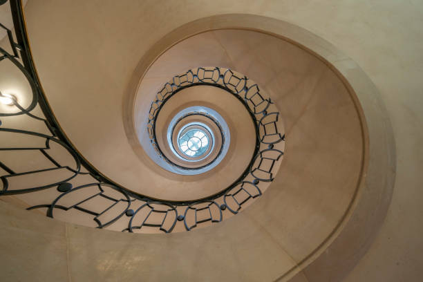 istock Paris, France - 08 26 2023: View of a circular stone staircase and iron stair railing seen from bottom 1644521631