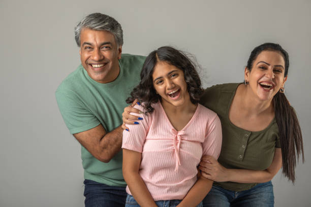 istock Loving parents embracing daughter over white background 1644526466