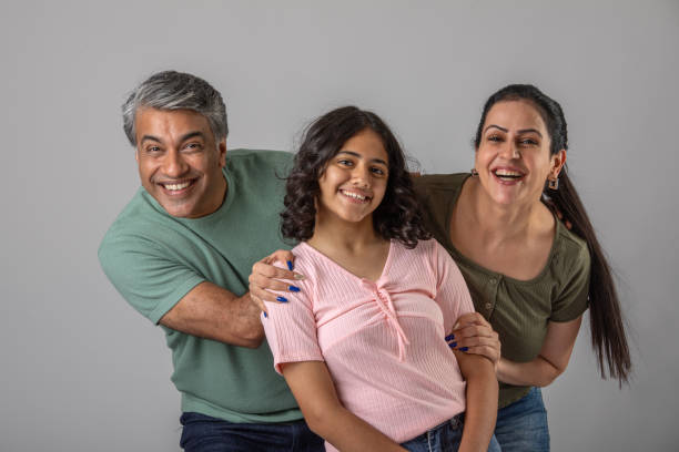 istock Loving parents embracing daughter over white background 1644526994