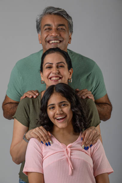 istock Smiling parents with daughter posing on white background 1644527557