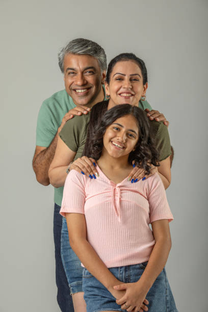 istock Smiling parents with daughter posing on white background 1644528079