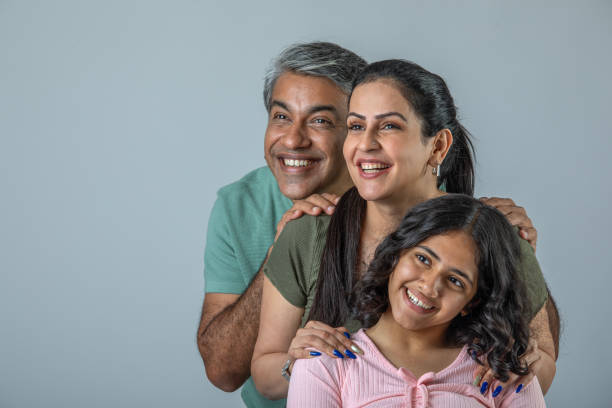 istock Loving parents embracing daughter over white background 1644528630