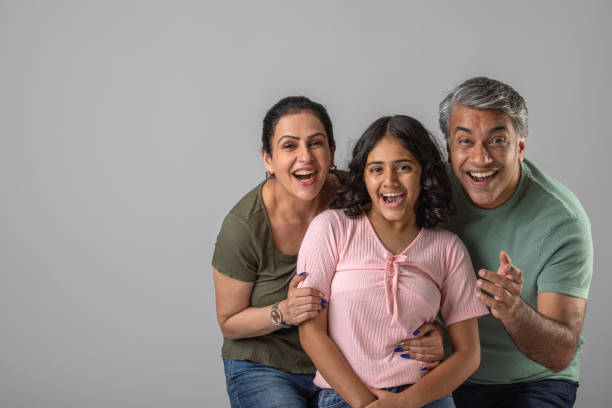 istock Loving parents embracing daughter over white background 1644529185