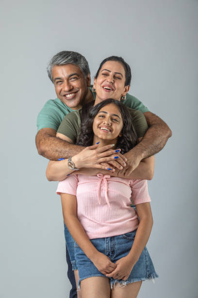 istock Loving parents embracing daughter over white background 1644530802
