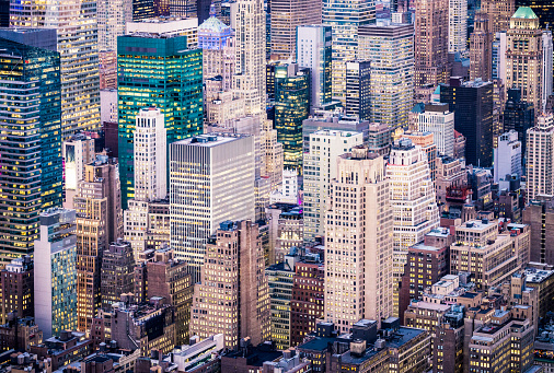 A high angle view at dusk across multiple office and apartment buildings in Manhattan, New York City.