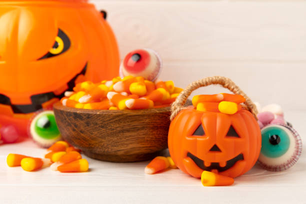 istock Halloween candy corn,jelly eye, pumpkin candy, sugar skull in different bowls on  background.Classic candy sweets for Halloween with.Halloween holiday concept with candy corn and jack o lantern. 1644546081