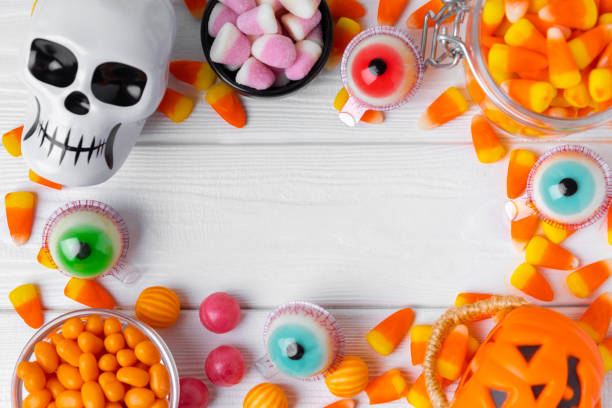 istock Halloween candy corn,jelly eye, pumpkin candy, sugar skull in different bowls on  background.Classic candy sweets for Halloween with.Halloween holiday concept with candy corn and jack o lantern. 1644546602