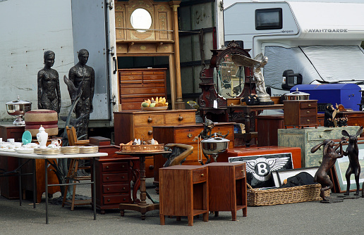 Typical merchandise at a flea market stall in Paris, France: dishware, candleholders, jewel boxes and decorative figures