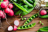 Table top view of green peas and radish on wooden table