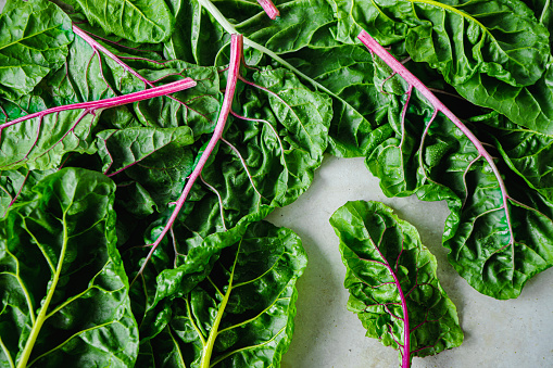 Fresh organic chard on table.  Top view of green leaves of Swiss Chard flay lay on table.