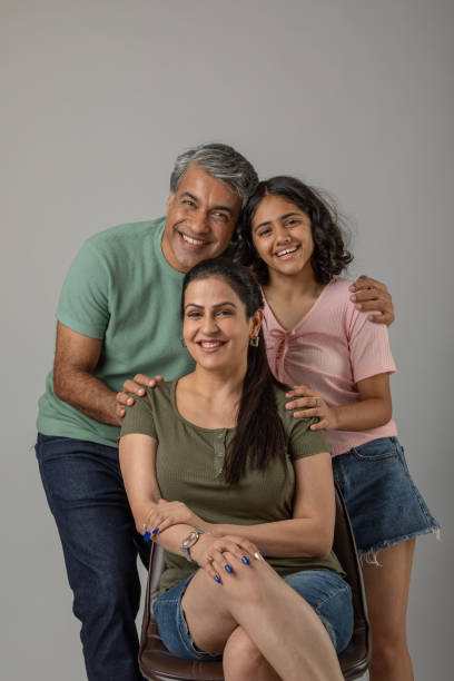 istock Loving parents embracing daughter over white background 1644576753