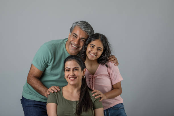 istock Loving parents embracing daughter over white background 1644577012