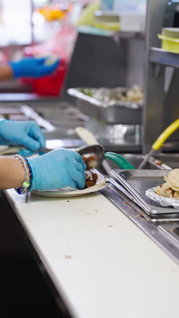 Vertical Shot of Restaurant Employee Preparing Tacos