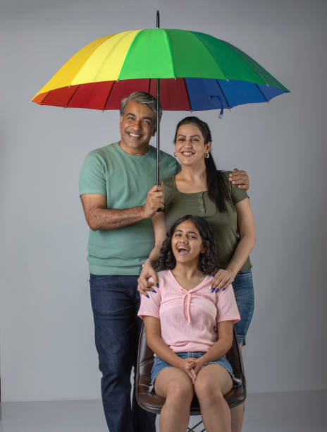 istock Parents and daughter with umbrella against white background 1644578387