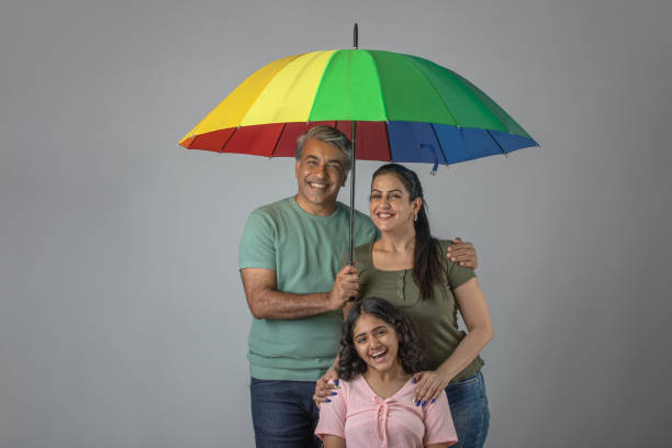 istock Parents and daughter with umbrella against white background 1644578925