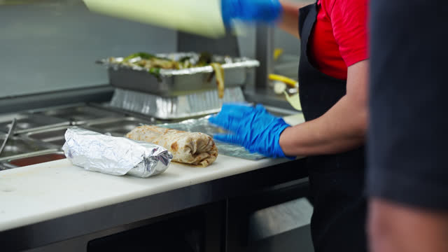 Restaurant Worker Wrapping up Burritos