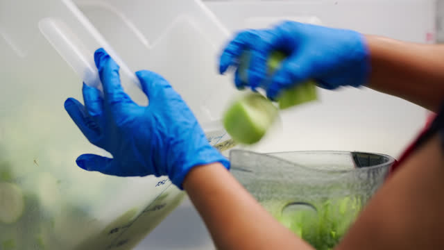 Closeup of Restaurant Worker Pouring Limes into Blender