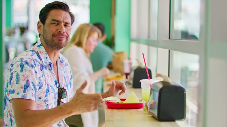 Man Gestures Thumbs-up To Camera While Eating Mexican Food