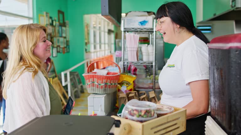 Woman Talking to Restaurant Owner While Placing Order