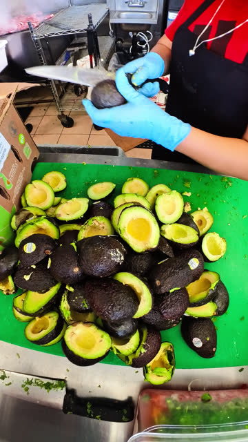 Restaurant Worker Cutting up Avocados to Prepare Guacamole