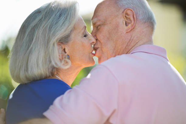 istock Romantic Senior Couple Kissing In Park 164461407