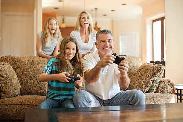 Happy Caucasian family having fun playing videogames Happy Caucasian family having fun playing videogames at homehttp://i449.photobucket.com/albums/qq220/iphotoinc/KidsBanner.jpg teenager couple child blond hair stock pictures, royalty-free photos & images