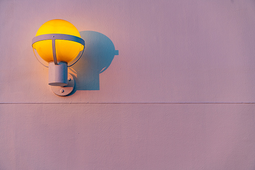 Outdoor wall lamp in white background at dusk