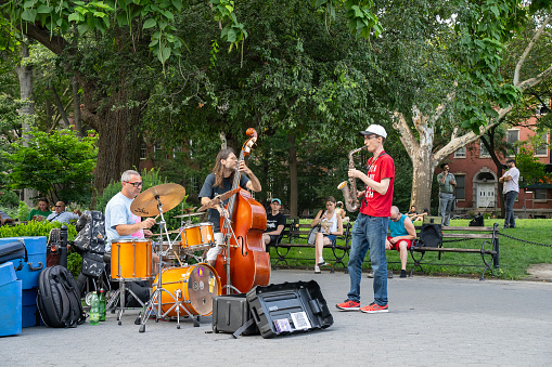 New York, USA - July 21st, 2023: A three men jazz band, playing in the Washington square park.