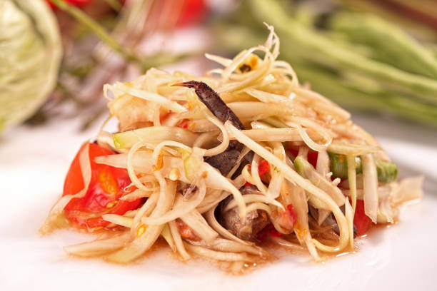 Papaya salad with crab and fermented fish topped with raw peel acacia seeds. Thai food