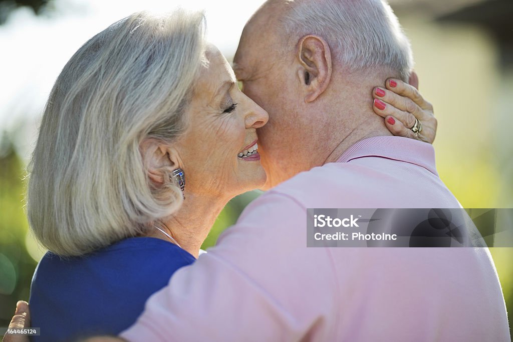 Starszy kobieta obejmować mąż w parku - Zbiór zdjęć royalty-free (60-69 lat)