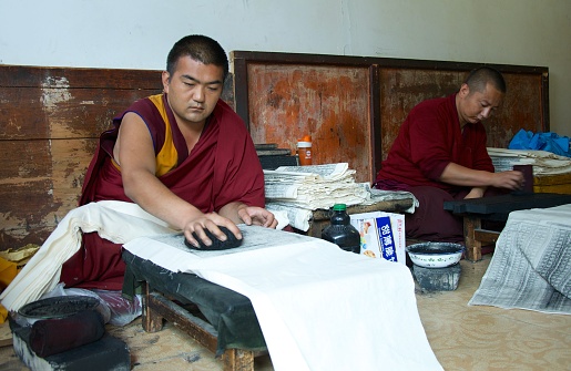 Xining, China- January 22, 2012: A Tibetan monk creats scripts  at Kumbum temple