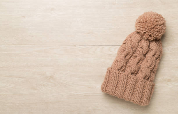 istock Brown winter hat on wooden background. Top view 1644663428