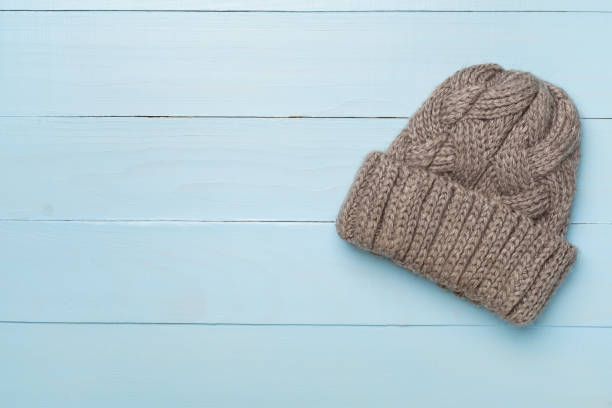istock Grey winter hat on wooden background. Top view 1644663429