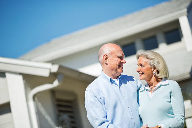 istock Senior Couple Standing With House In Background 164469647
