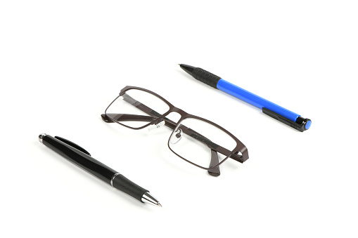 Business blue and black ballpoint pen with reading glasses isolated on white background. Office and secretarial concept. High resolution photo. Full depth of field.