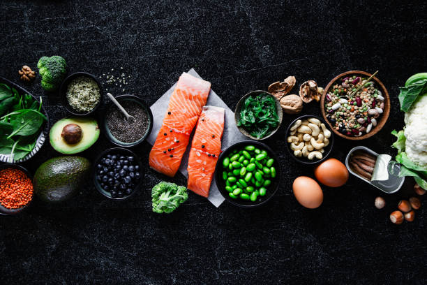 Top view of Omega 3 food items on black table Top view of Omega 3 food items on black table. Table top view of fresh spinach, walnuts,  broccoli, lentil seeds, chia seeds, avocado, beans in bowls on a table. keto diet stock pictures, royalty-free photos & images