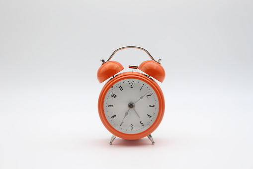 Orange color alarm clock with white background, front view