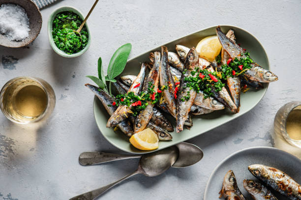 istock Fresh small silver fish with spices and lemon on a plate 1644751127