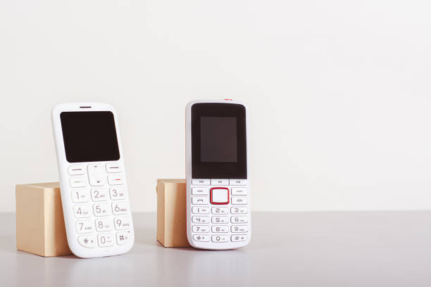 istock Two old-fashioned white push-button telephones are on the table 1644751656