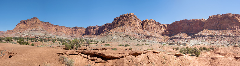 Beautiful red and orange rock formations make au Capitol Reef and Cathedral Valley in Utah. They give this desert land an otherworldly look. panorama photo