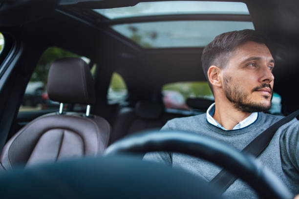 istock A Happy Handsome Businessman Looking Away While Driving His Car 1644775761