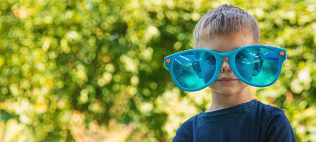 Children enjoy nature in glasses. Selective focus. Nature.