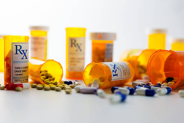 Prescription Pills Prescription bottles and pills on a counter. capsule medicine stock pictures, royalty-free photos & images