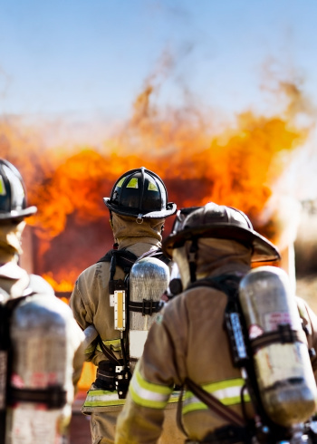 Three firefighters putting out an house fire. Vertical shot.  FIRE - Exclusive only at istockphoto.