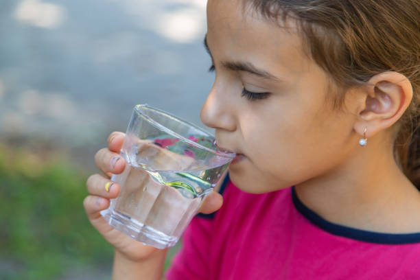 istock The child drinks water from a glass. Selective focus. 1644782807