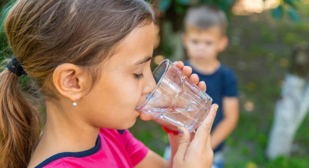 istock The child drinks water from a glass. Selective focus. 1644782813