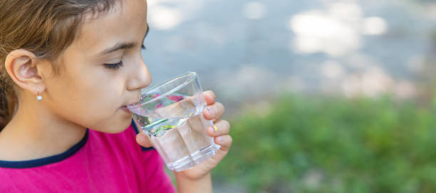 istock The child drinks water from a glass. Selective focus. 1644783337