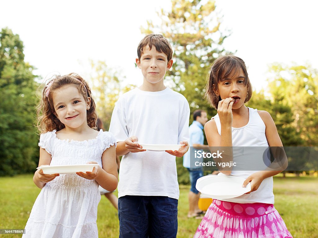 Dzieci jedzenia na zewnątrz. - Zbiór zdjęć royalty-free (Afroamerykanin)