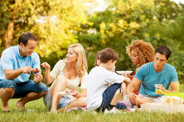 Mixed race family enjoying a picnic at a table in a park